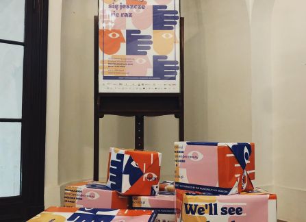 A photograph. The main hall of villa decius. in the center cardboard boxes with books packed in colorful paper promoting the action multicultural library.